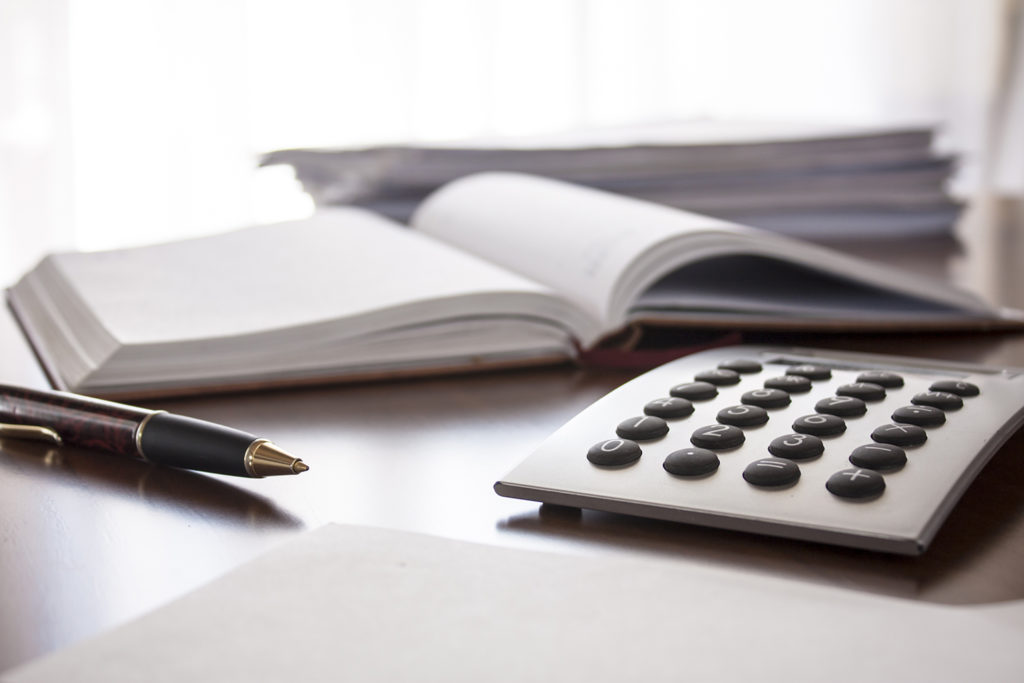 Calculator, pen and ledgers to represent tax planning