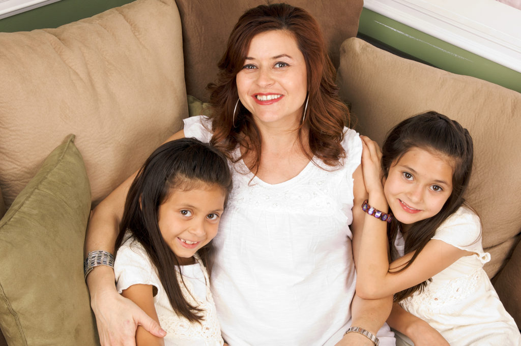 mother and two daughters on couch