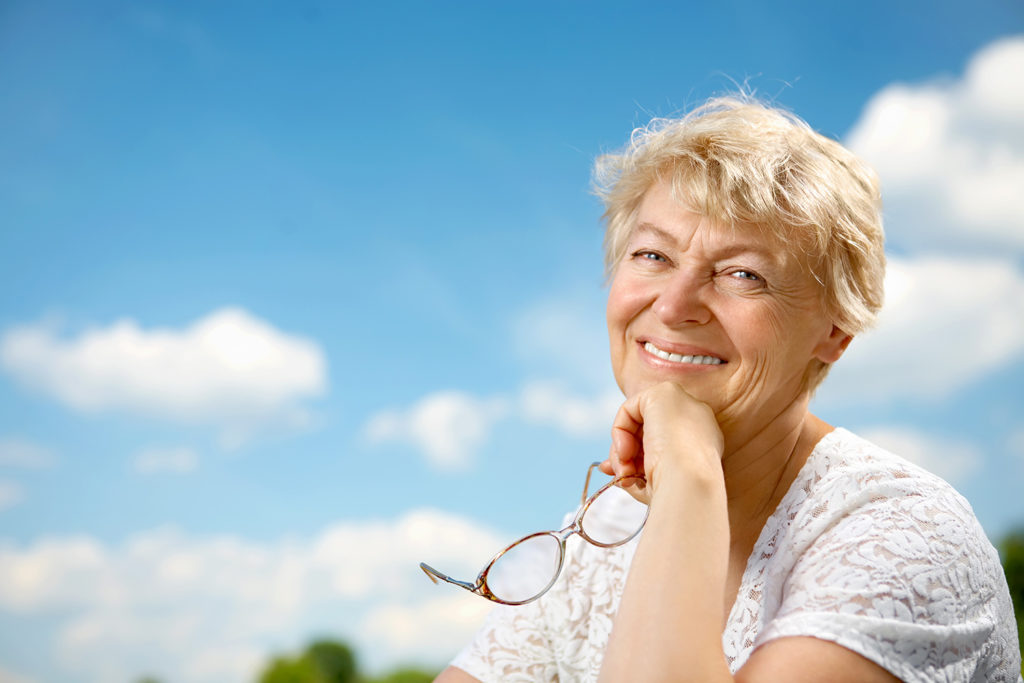 Smiling elderly woman by herself. Representing estate planning for a wealthy widow.